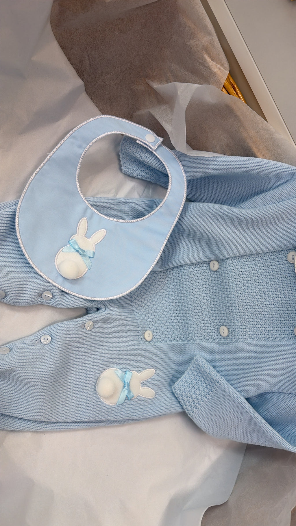 Blue knit babygrow and bib
